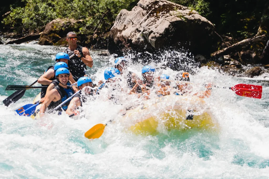 Several individuals navigating a river in a raft, enjoying the adventure amidst scenic natural surroundings.