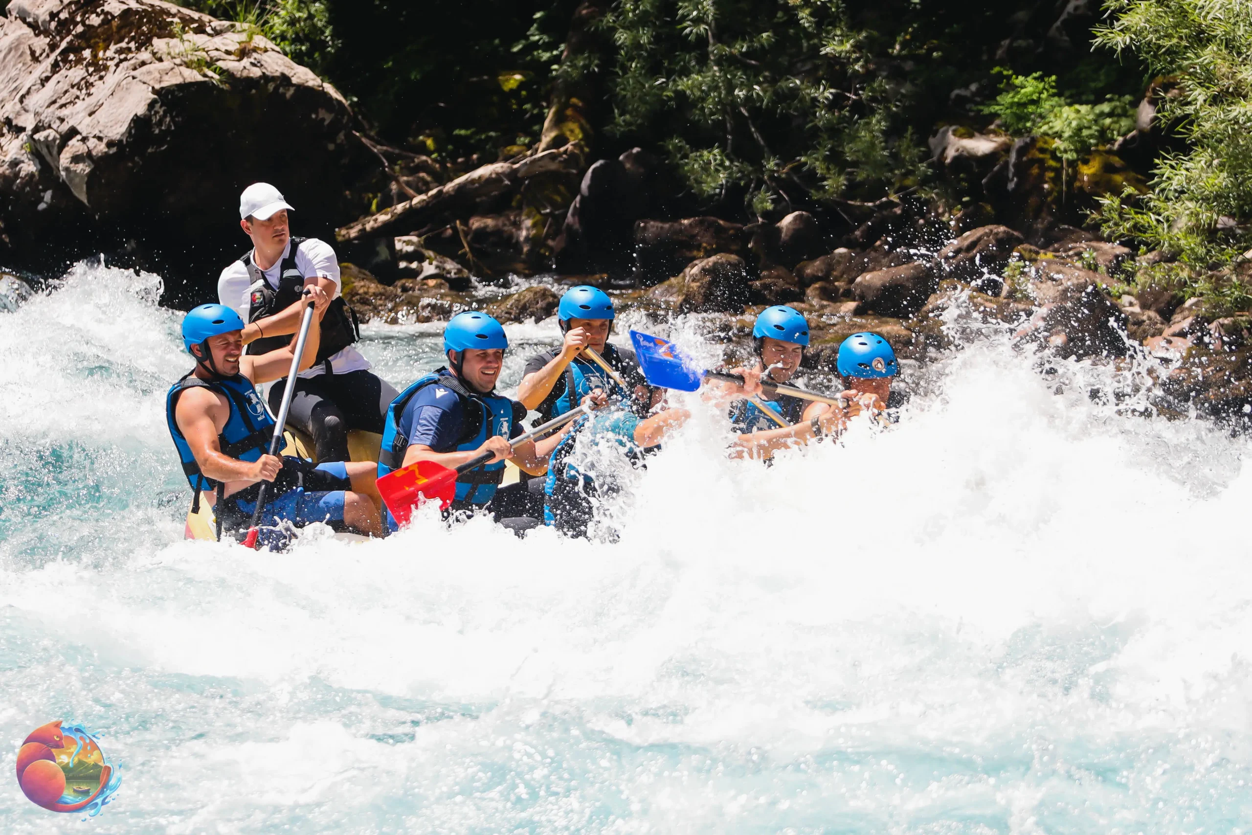 Naslovna Several individuals navigating a river in a raft, enjoying the adventure amidst scenic natural surroundings.