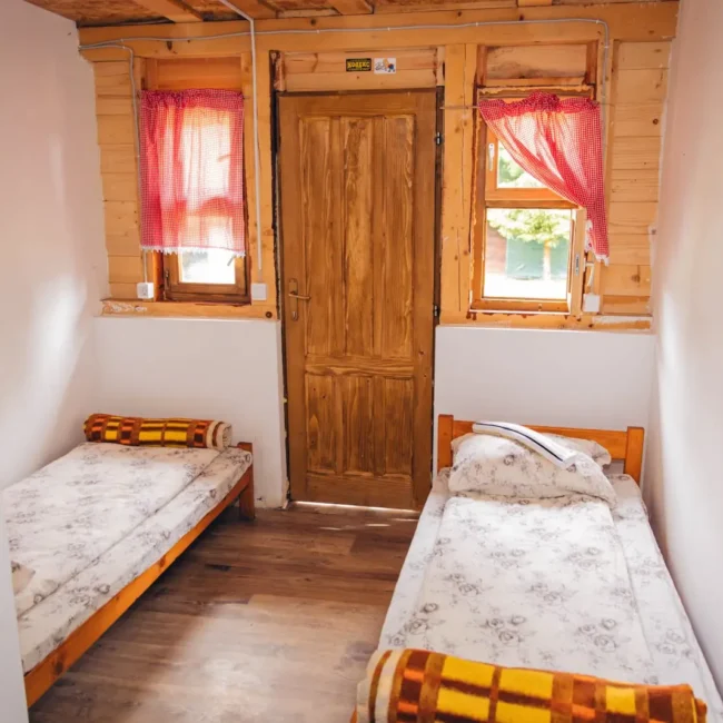 2 wooden beds beds with clean sheets in a cosy bungalow