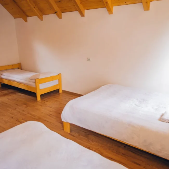 Cozy bedroom with two wooden beds with floral bedding.